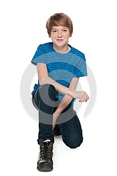 Preteen boy sits on the white background