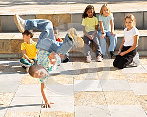 Preteen boy street breakdancer performing acrobatic elements