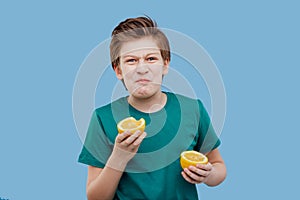 Preteen boy taste a fresh lemon, sour taste