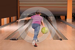 Preteen boy throwing ball at bowling