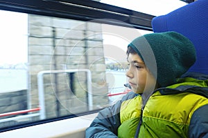 Preteen boy in train look at window