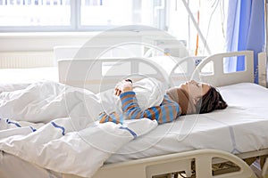 Preteen child, boy, lying in hospital with fractured thoracic spine, vertebralis