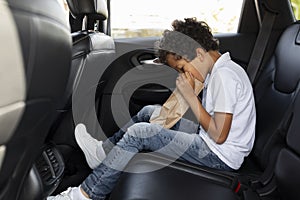 Preteen child in car backseat breathing in paper bag