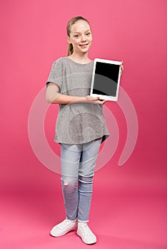 preteen child presenting digital tablet with blank screen, isolated