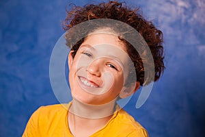 Preteen curly boy smiling and looking at camera