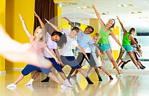 Preteen dancers practicing dance routine with female choreograph