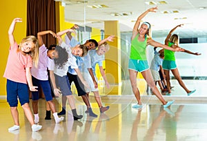 Preteen dancers practicing dance routine with female choreograph photo