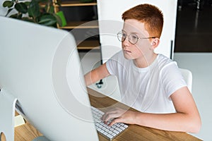 preteen ginger hair boy using computer