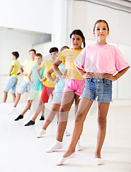 Preteen girl with children practicing ballet moves during choreography class