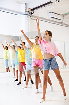 Preteen girl with children practicing ballet moves during choreography class