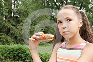 Preteen girl eats bread photo