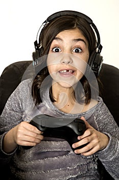 Preteen girl with eyes wide open playing video game excited