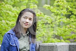 Preteen girl outdoors with green trees in backgro