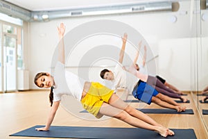 Preteen girl practicing Vasisthasana or Side Plank pose during family yoga workout