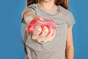 Preteen girl with slime on blue background