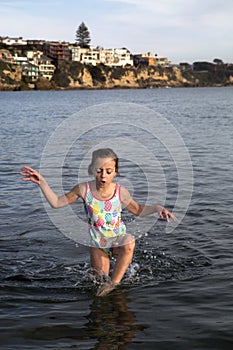 Preteen girl in swimsuit playing in the Pacific Ocean Newport Be