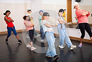 Preteen girl training hip-hop during group dance lesson