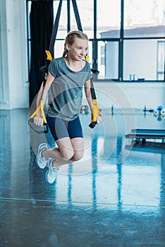Preteen girl training with resistance bands in fitness class
