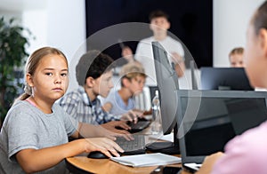 Preteen girl working with computer programs in training room