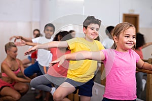 Preteen girl working near ballet barre during group class