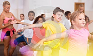 Preteen girl working near ballet barre during group dance class