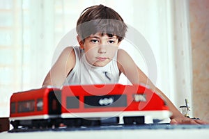 Preteen handsome boy play with meccano toy train and railway sta photo