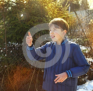 preteen handsome boy toss a coin on the country spring sunny village background