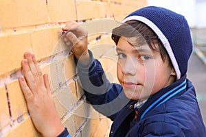 preteen handsome boy try himself as a graffiti artist on the yellow brick wall