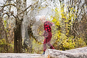 Preteen kid balance on fallen tree trunk