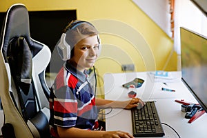 Preteen kid boy playing computer games on desktop pc. Modern addict activity for children. Young child gaming at home