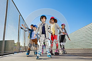 Preteen kids rollerblading outdoors at stadium