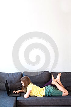 Preteen schoolgirl using laptop for distance education.