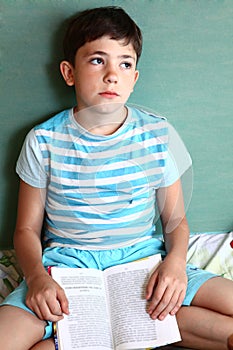 Preteens handsome boy with book tired closed hes eyes