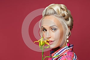 Prett pin-up woman with flowers on red. Beautiful retro model portrait