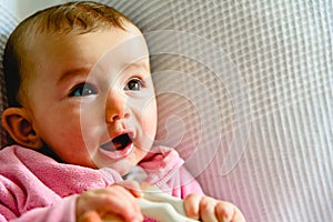 Pretty and adorable 6 month old baby girl smiling while playing with her mother