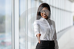 A pretty african american business woman offering a handshake in office