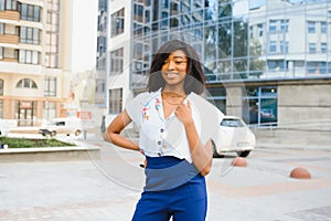 A pretty African american business woman talking on a cell phone at office building