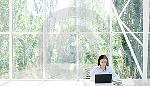 Pretty african american businesswoman working on laptop sitting at her desk in modern creative office