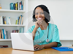 Pretty african american doctor at computer