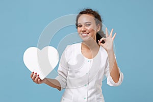 Pretty african american female doctor woman in medical gown hold white blank empty heart showing OK sign isolated on