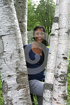 Pretty african american teen among birch trees