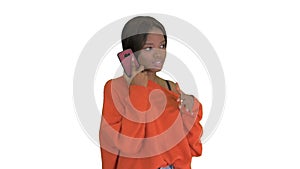 Pretty african american woman in bright jumper talking on the phone and gesturing emotionally on white background.