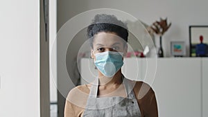 Pretty African American woman puting a medical mask then removing and sighing with relief. Young female mixed race