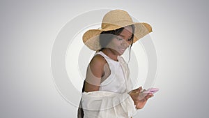 Pretty african american woman in a straw hat texting on her phon