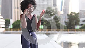 A pretty African american woman talking on a cell phone at office building in the city