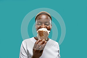 Pretty african with closed eyes keeping waffle of ice cream