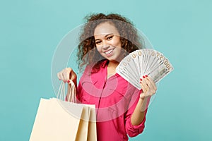 Pretty african girl hold package bag with purchases after shopping, fan of money in dollar banknotes, cash money