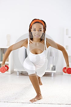 Pretty afro woman with dumbbells