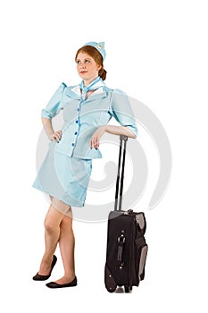 Pretty air hostess leaning on suitcase