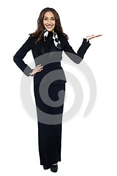 Pretty air hostess presenting copy space with open palm